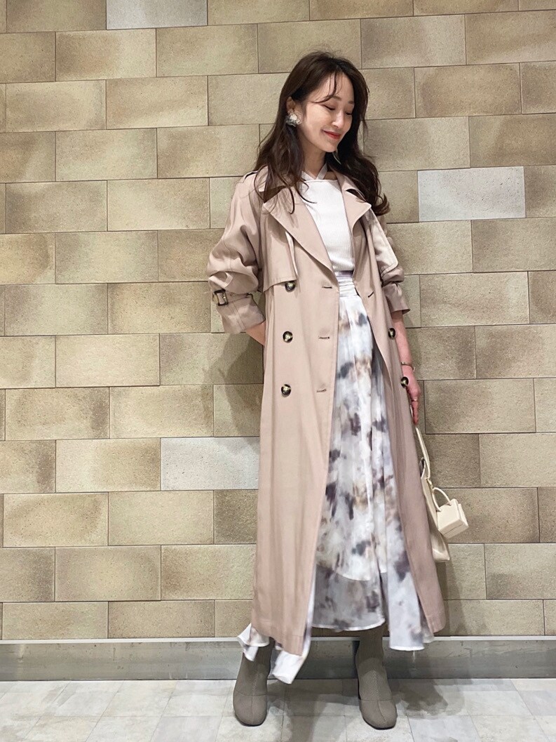 ベージュ系のトレンチコート、ベージュ系のトートバッグ、ホワイト系のニット/セーターを着用したレディースの冬コーディネートの6枚目の写真