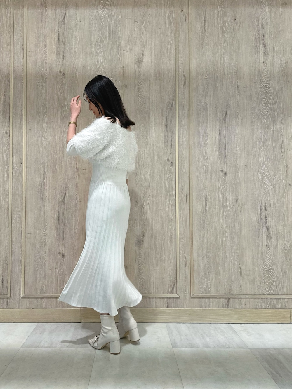 ホワイト系のブーツ、ホワイト系のワンピース、ゴールド系のイヤリングを着用したレディースの春コーディネートの3枚目の写真