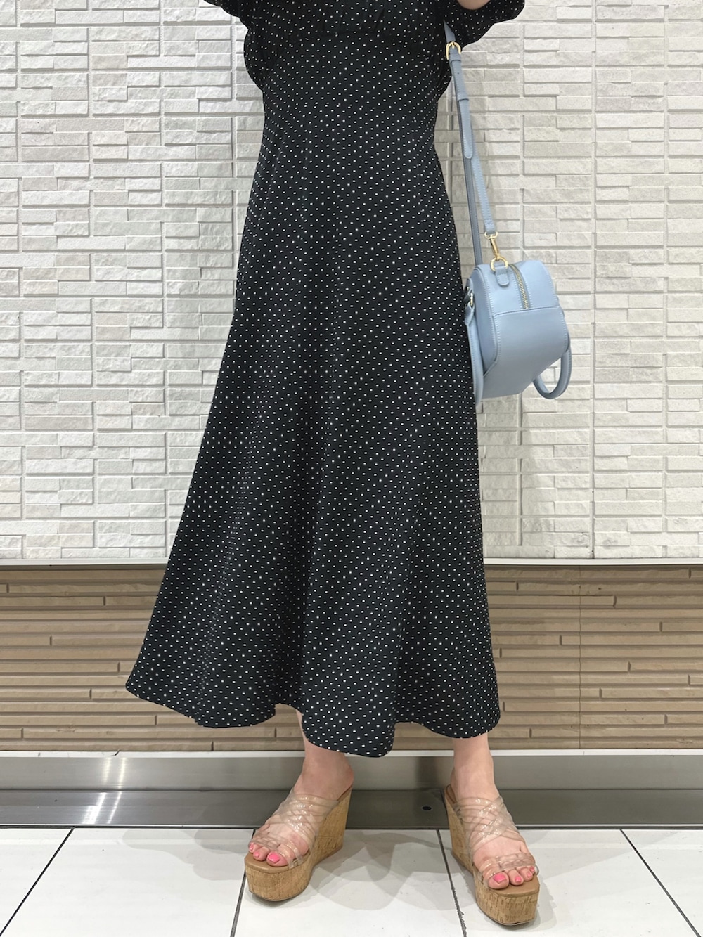 その他のサンダル、ブラック系のワンピース、ブルー系のボストンバッグを着用したレディースの夏コーディネートの6枚目の写真
