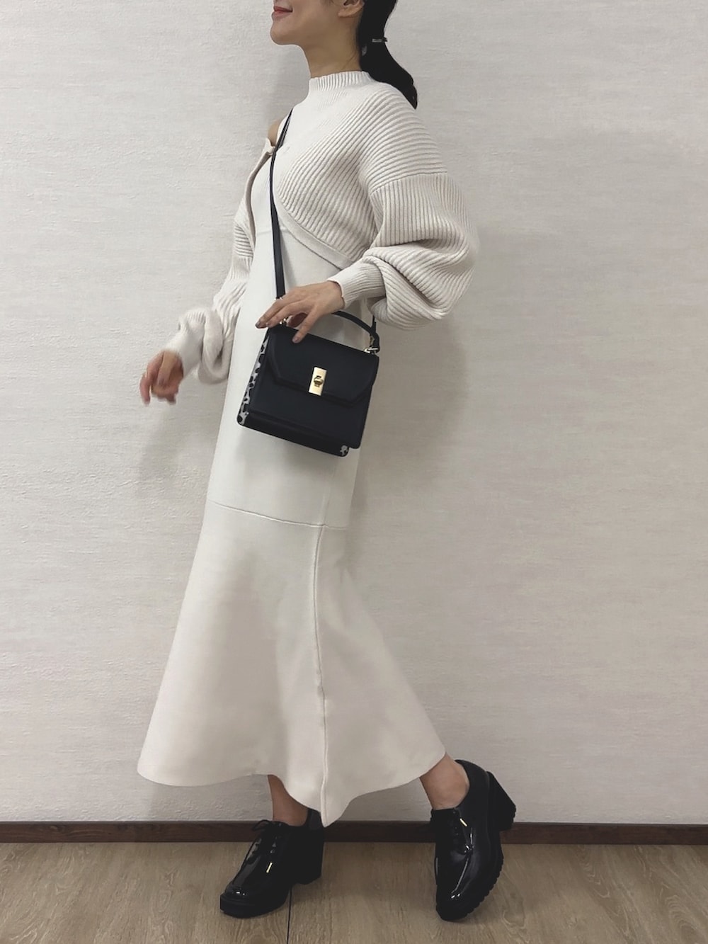ホワイト系のワンピース、ブラック系のハンドバッグ、ブラック系のローファーを着用したレディースの秋コーディネートの3枚目の写真
