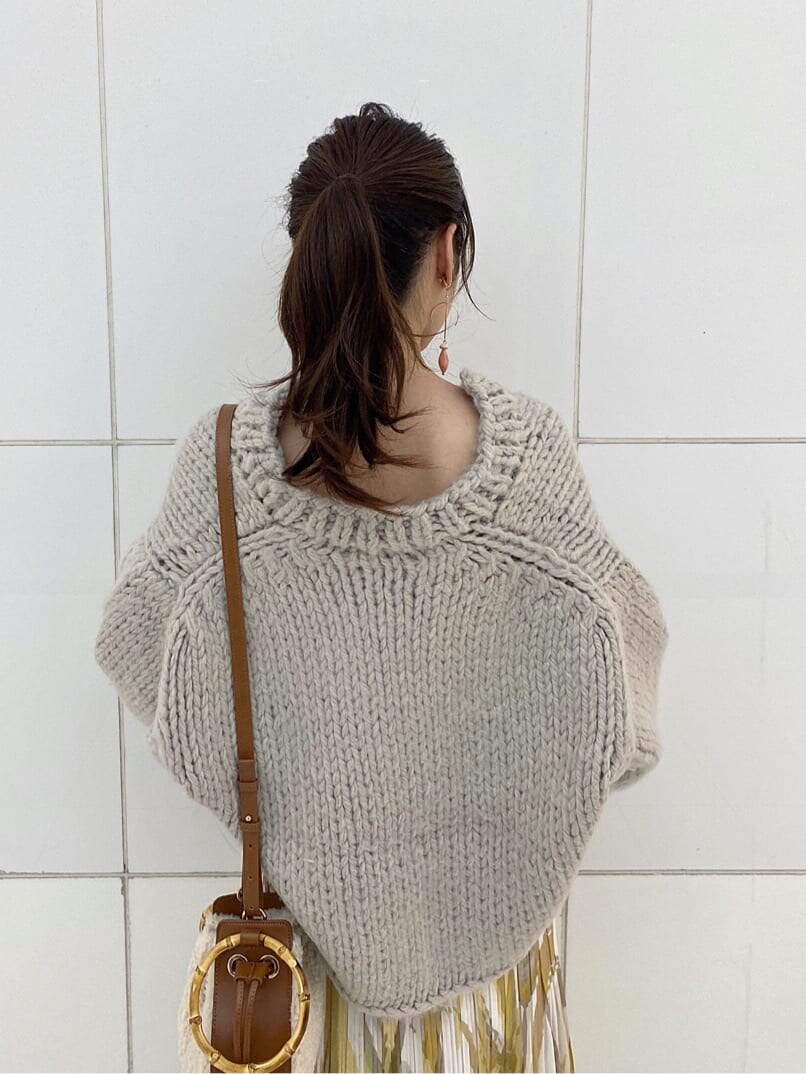 イエロー系のスカート、グレー系のニット/セーター、ベージュ系のブーツを着用したレディースの秋コーディネートの9枚目の写真