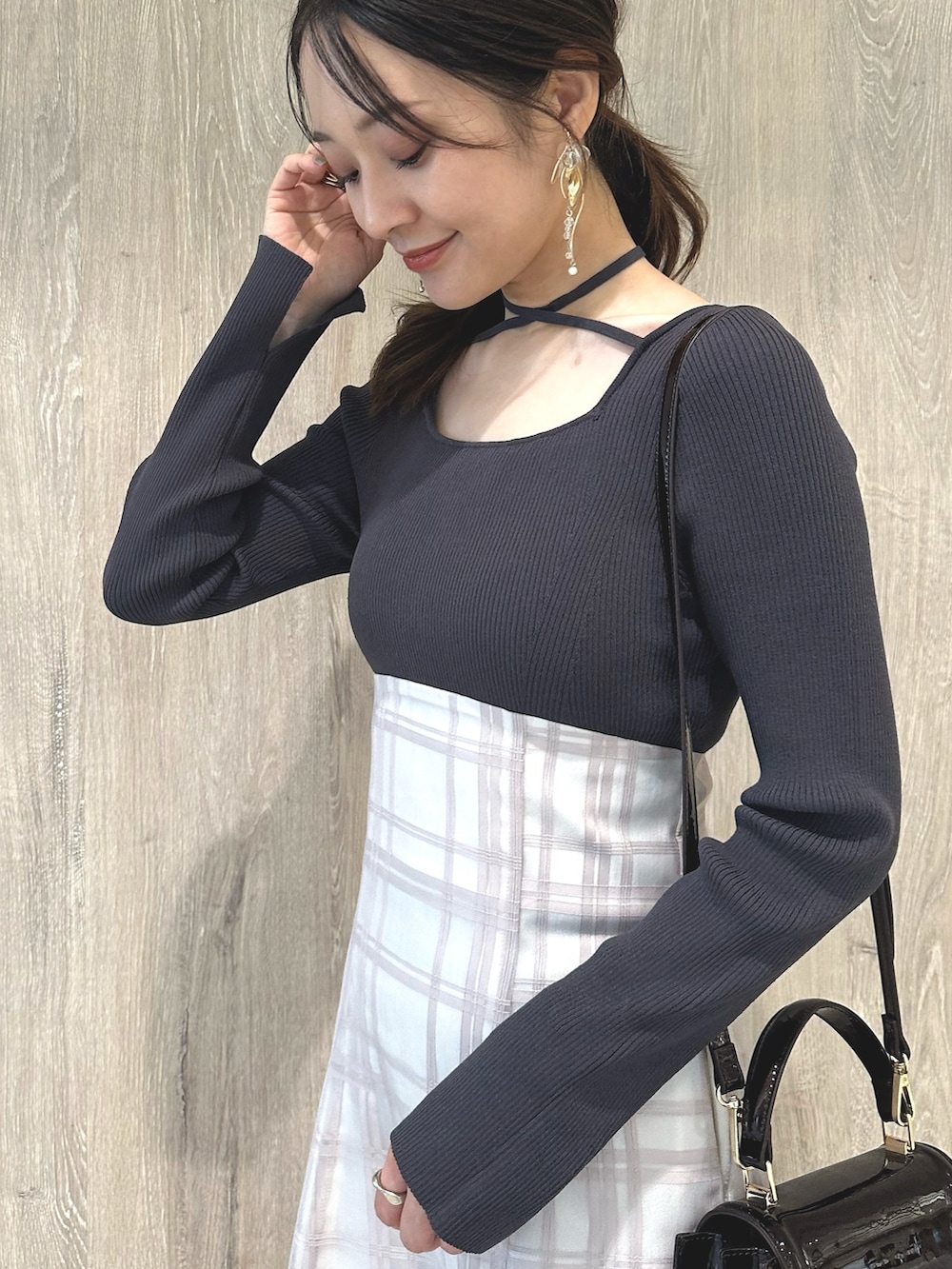 レッド系のハンドバッグ、ブラウン系のパンプス、グレー系のワンピースを着用したレディースの秋コーディネートの6枚目の写真