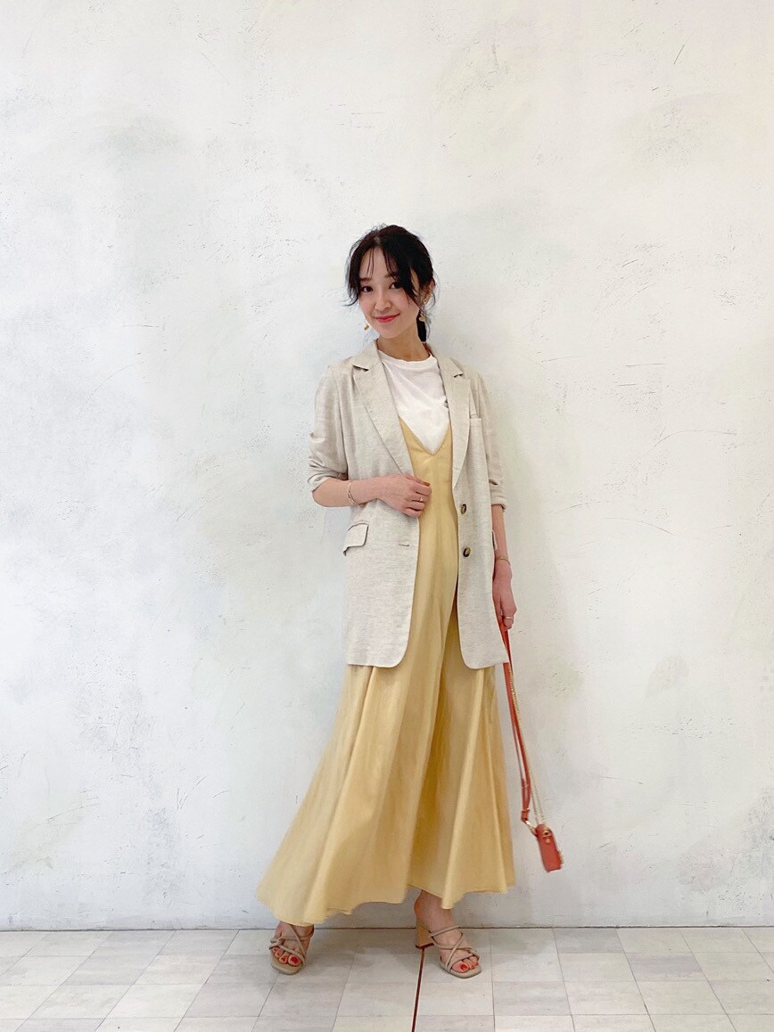 イエロー系のワンピース、ベージュ系のニット/セーター、ホワイト系のテーラードジャケットを着用したレディースの春コーディネートの4枚目の写真