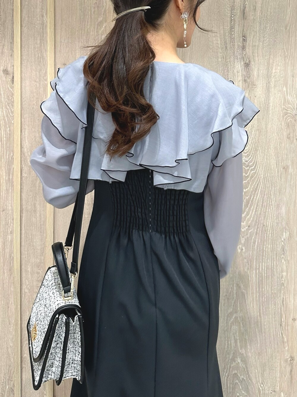 ブラック系のショルダーバッグ、グレー系のワンピース、ブラウン系のパンプスを着用したレディースの冬コーディネートの7枚目の写真