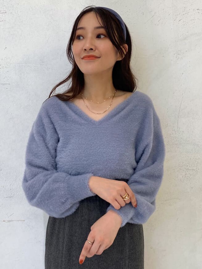 ホワイト系のブーツ、グレー系のスカート、ブルー系のニット/セーターを着用したレディースの秋コーディネートの5枚目の写真