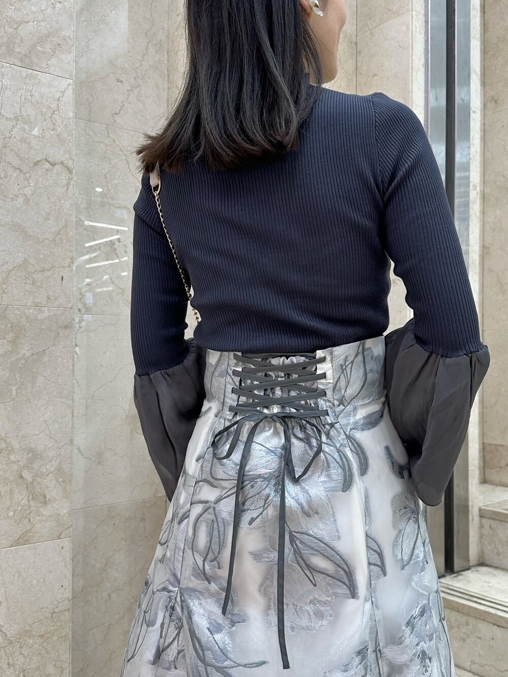 ブラウン系のブーツ、ピンク系のショルダーバッグ、グレー系のニット/セーターを着用したレディースの春コーディネートの7枚目の写真