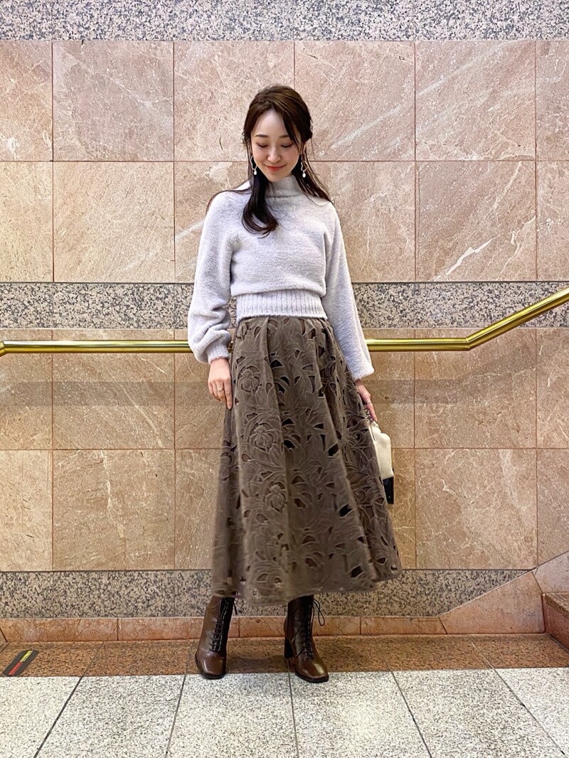 ホワイト系のハンドバッグ、パープル系のニット/セーターを着用したレディースの冬コーディネートの2枚目の写真