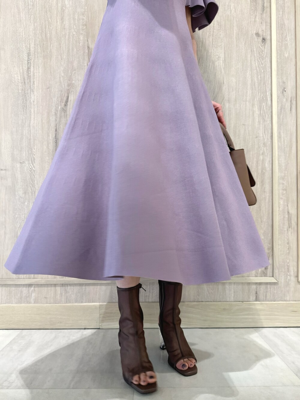 ブラウン系のハンドバッグ、ブラウン系のブーツ、パープル系のワンピースを着用したレディースの春コーディネートの8枚目の写真