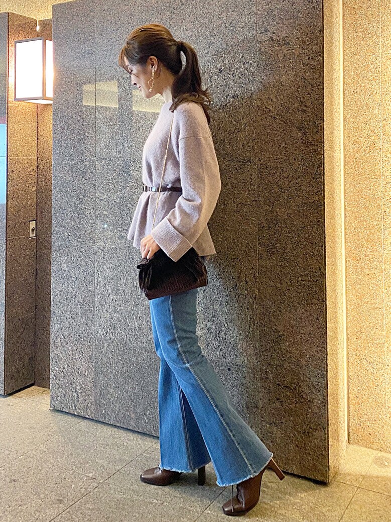 ベージュ系のその他アウター、ブラウン系のクラッチバッグ、ブルー系のその他パンツを着用したレディースの秋コーディネートの4枚目の写真