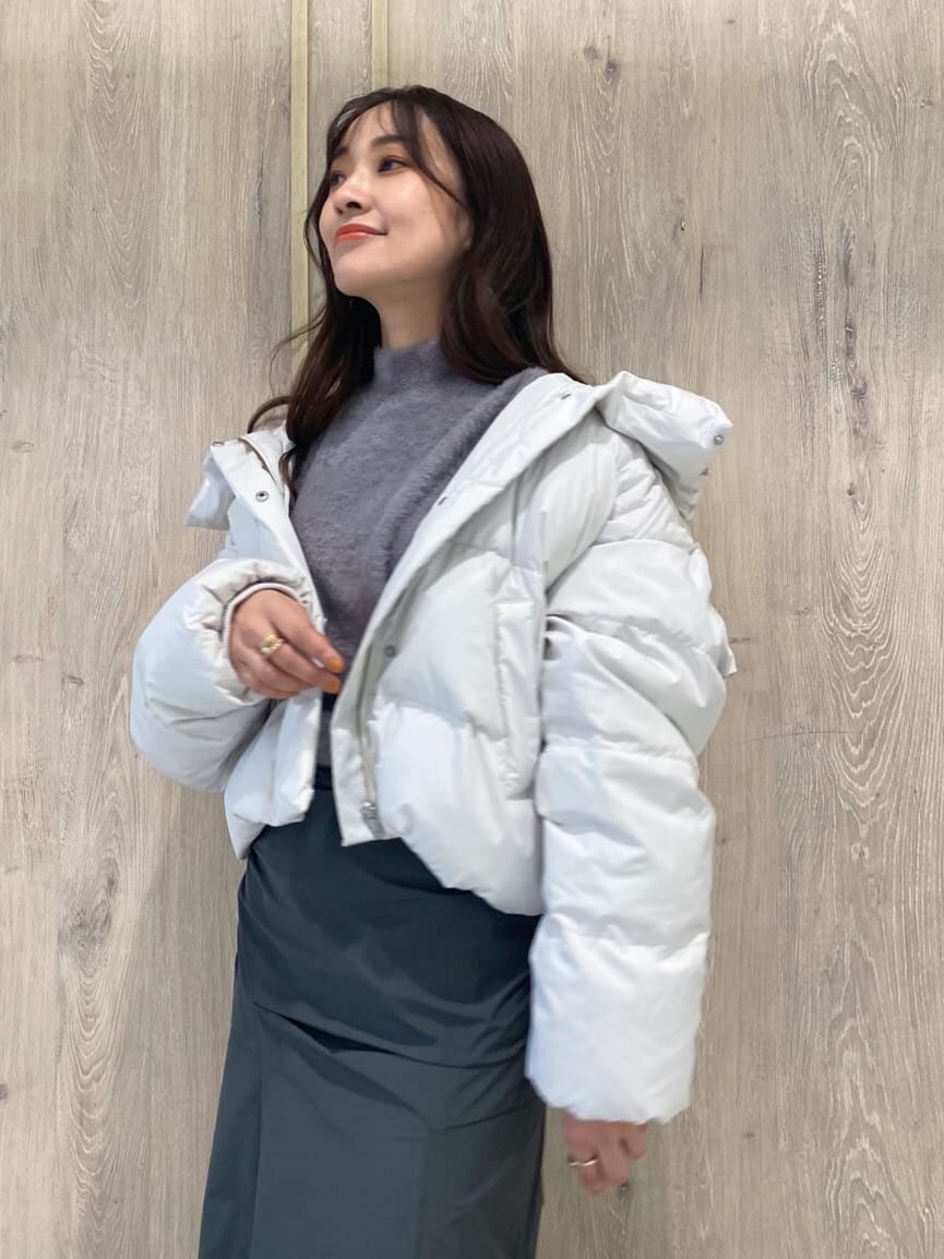 ホワイト系のダウンジャケット/コート、ブラック系のブーツ、パープル系のニット/セーターを着用したレディースの秋コーディネートの5枚目の写真