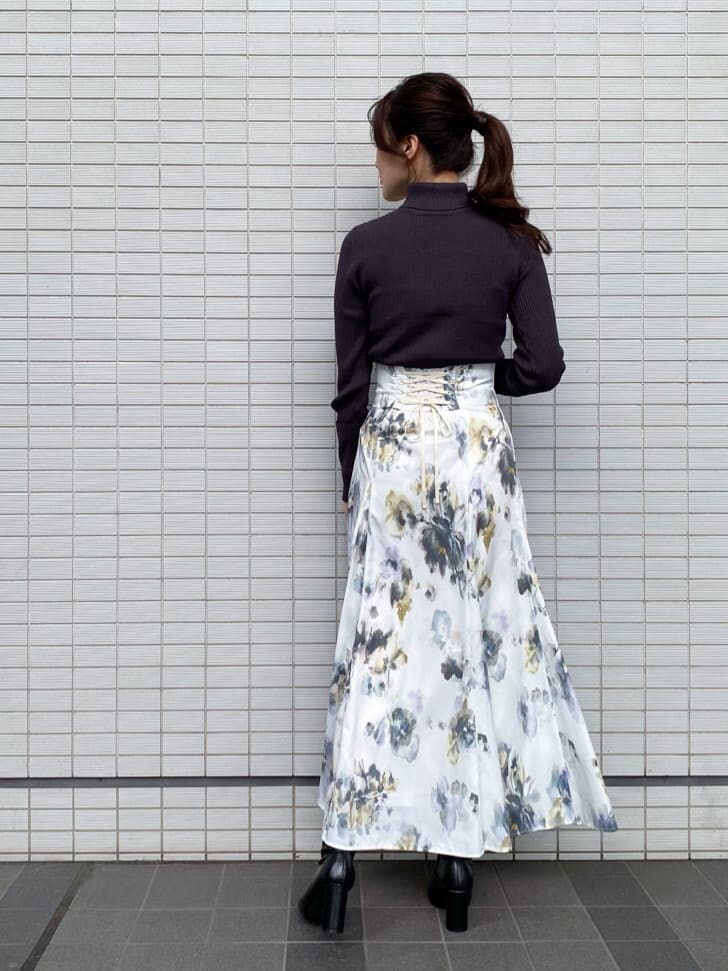 ブラック系のブーツ、グレー系のニット/セーター、ホワイト系のスカートを着用したレディースの秋コーディネートの4枚目の写真