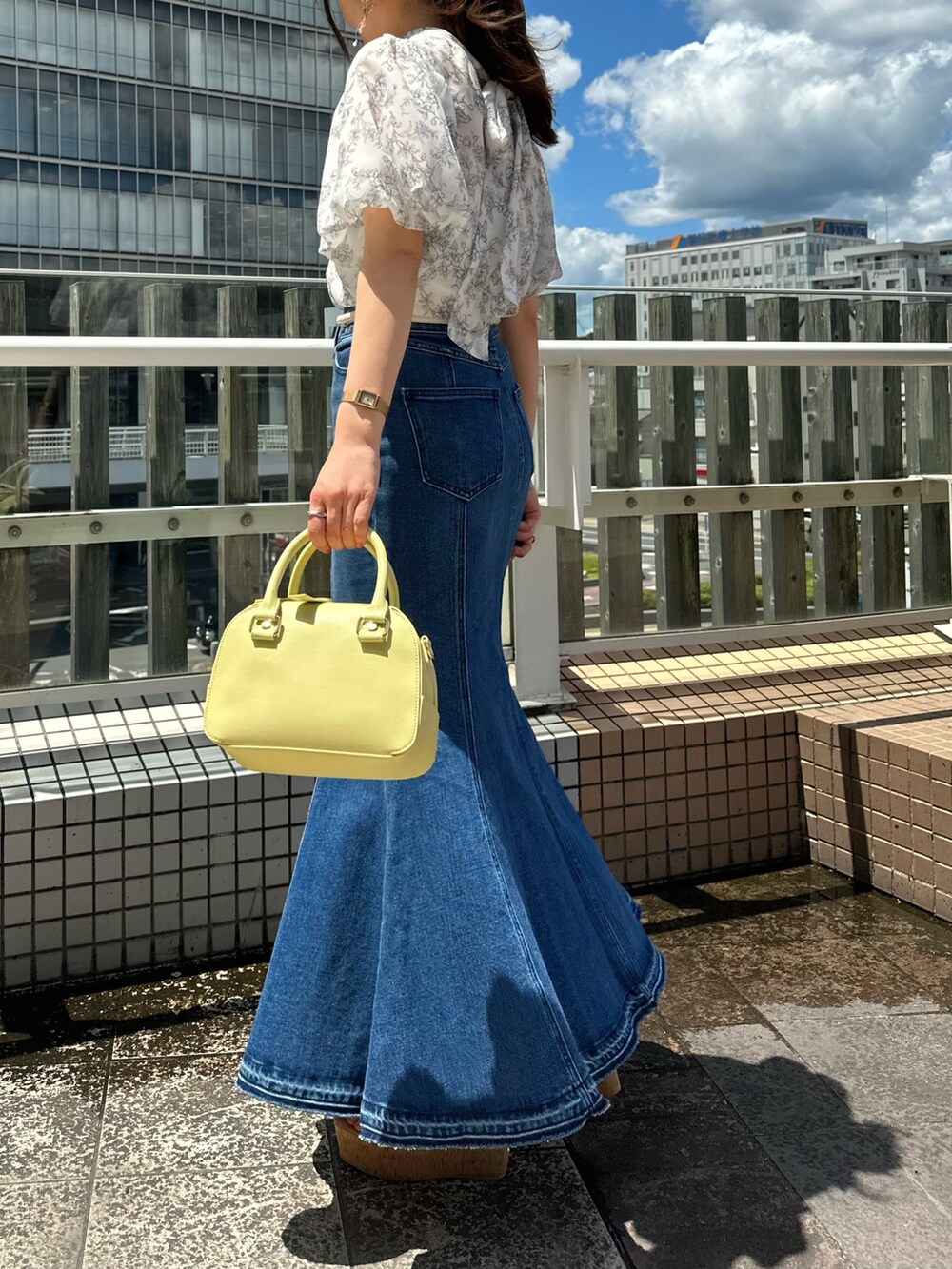 その他のサンダル、ブルー系のデニムスカート、グレー系のシャツ/ブラウスを着用したレディースの夏コーディネートの2枚目の写真