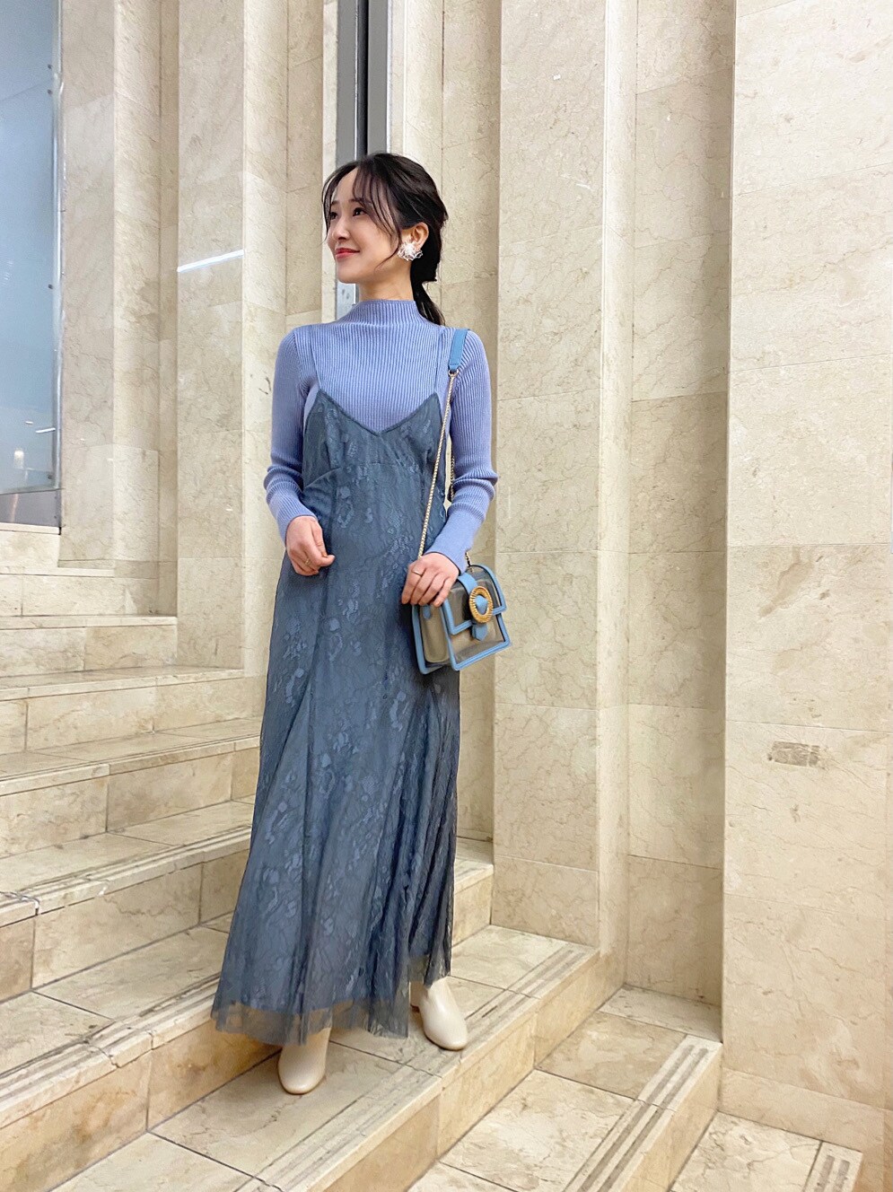 ホワイト系のブーツ、その他のイヤリングを着用したレディースの冬コーディネートの3枚目の写真