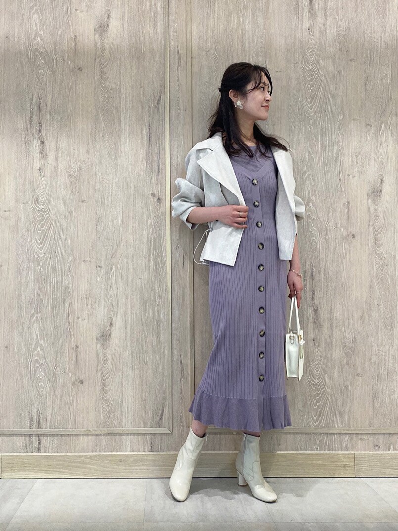 パープル系のワンピース、ホワイト系のブーツ、ホワイト系のハンドバッグを着用したレディースの冬コーディネートの2枚目の写真
