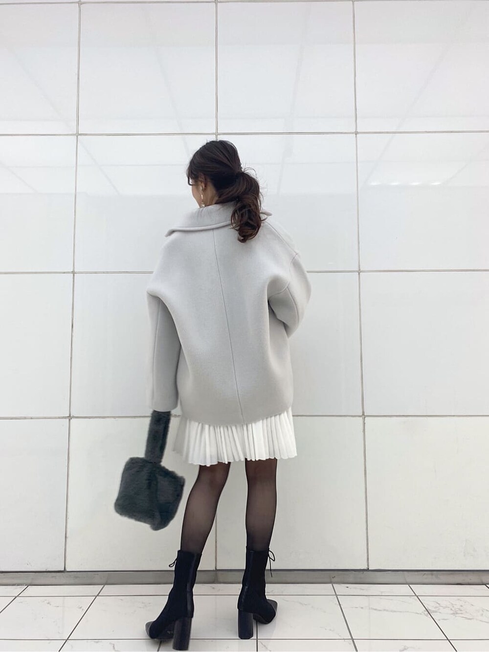 グリーン系のブルゾン、ブラック系のブーツ、グレー系のワンピースを着用したレディースの冬コーディネートの5枚目の写真