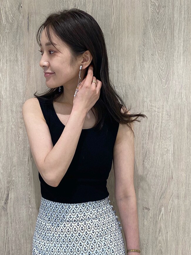 ホワイト系のハンドバッグ、ブルー系のスカート、ブラック系のニット/セーターを着用したレディースの夏コーディネートの7枚目の写真