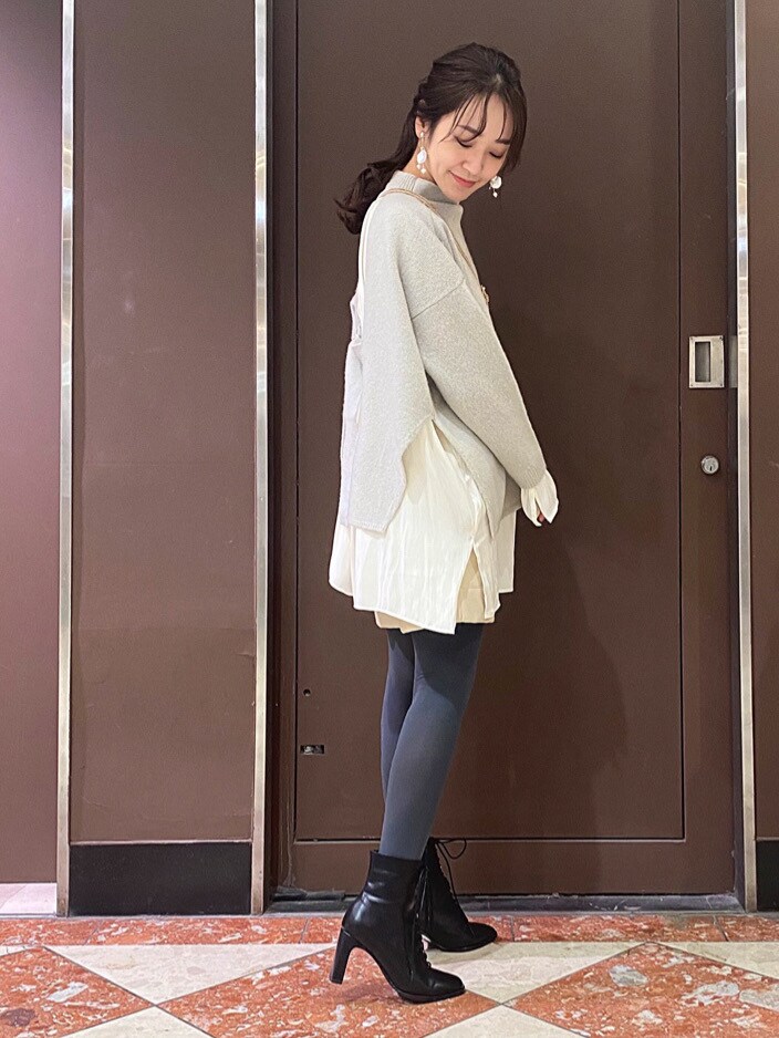 ホワイト系のその他パンツ、ベージュ系のハンドバッグ、グリーン系のニット/セーターを着用したレディースの冬コーディネートの2枚目の写真