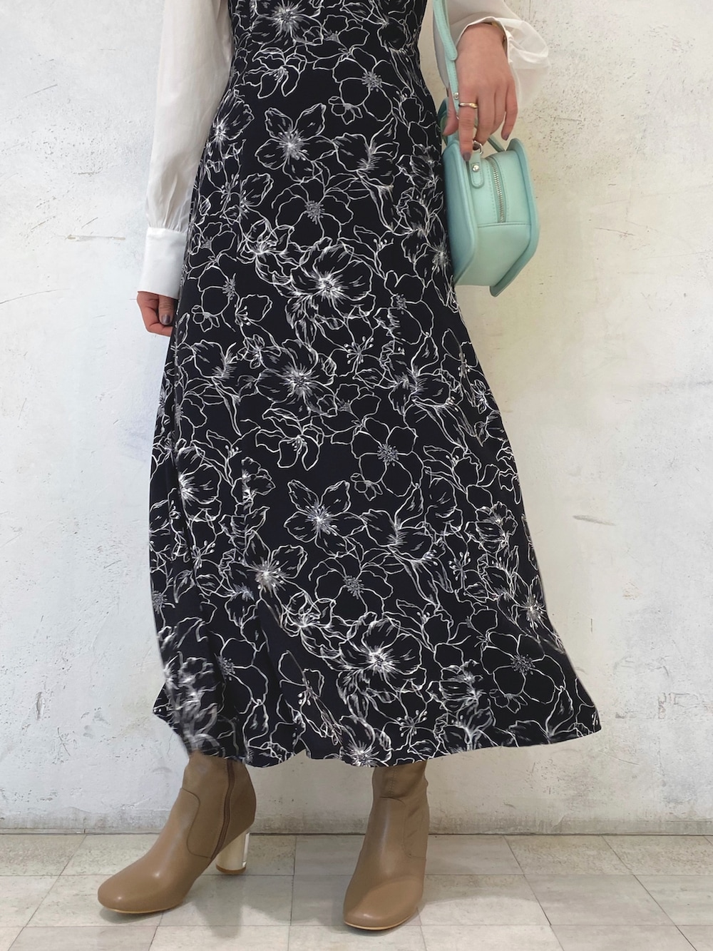 ベージュ系のブーツ、グリーン系のハンドバッグ、その他のワンピースを着用したレディースの冬コーディネートの8枚目の写真