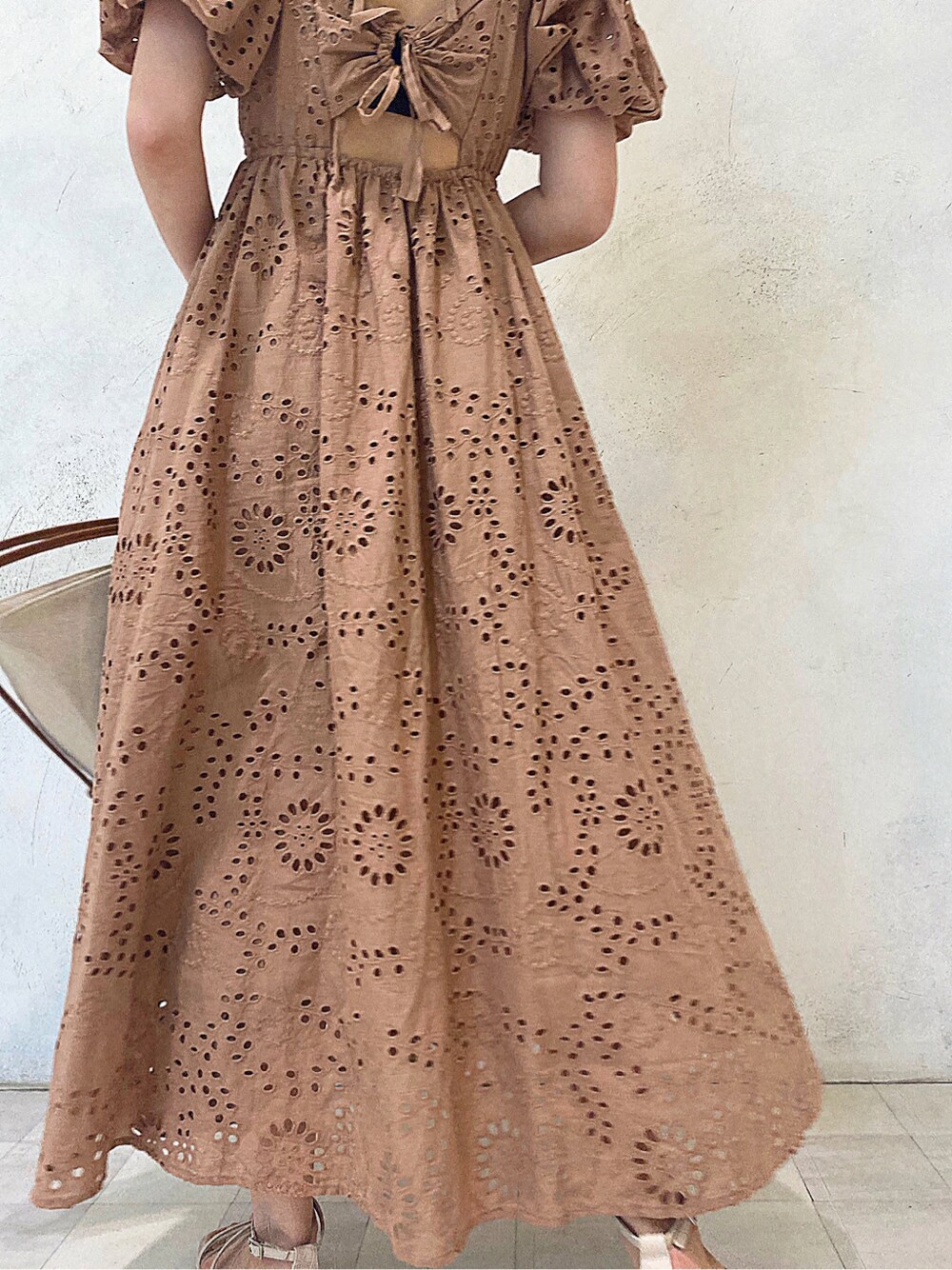 ブラウン系のトートバッグ、ベージュ系のワンピース、ベージュ系のサンダルを着用したレディースの春コーディネートの6枚目の写真