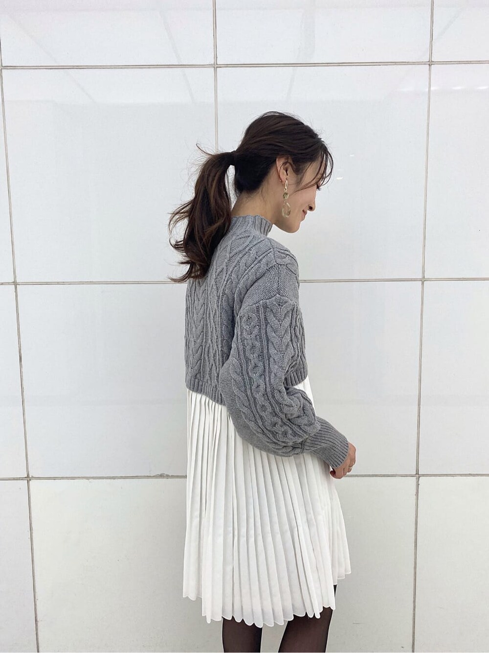 グリーン系のブルゾン、ブラック系のブーツ、グレー系のワンピースを着用したレディースの冬コーディネートの8枚目の写真