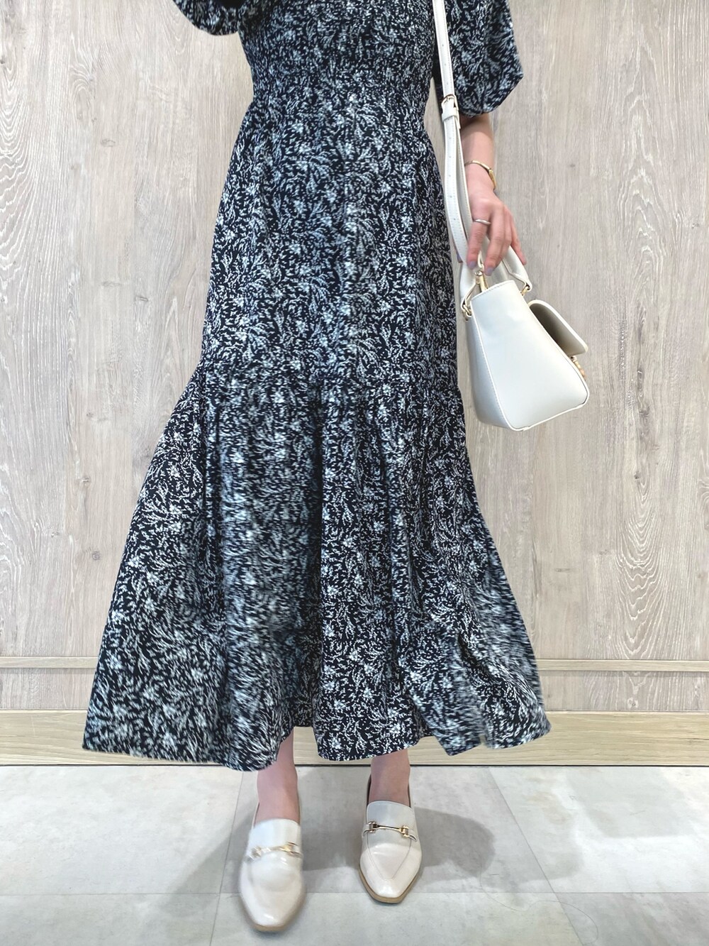 ホワイト系のローファー、ブラック系のワンピース、ホワイト系のハンドバッグを着用したレディースの冬コーディネートの8枚目の写真