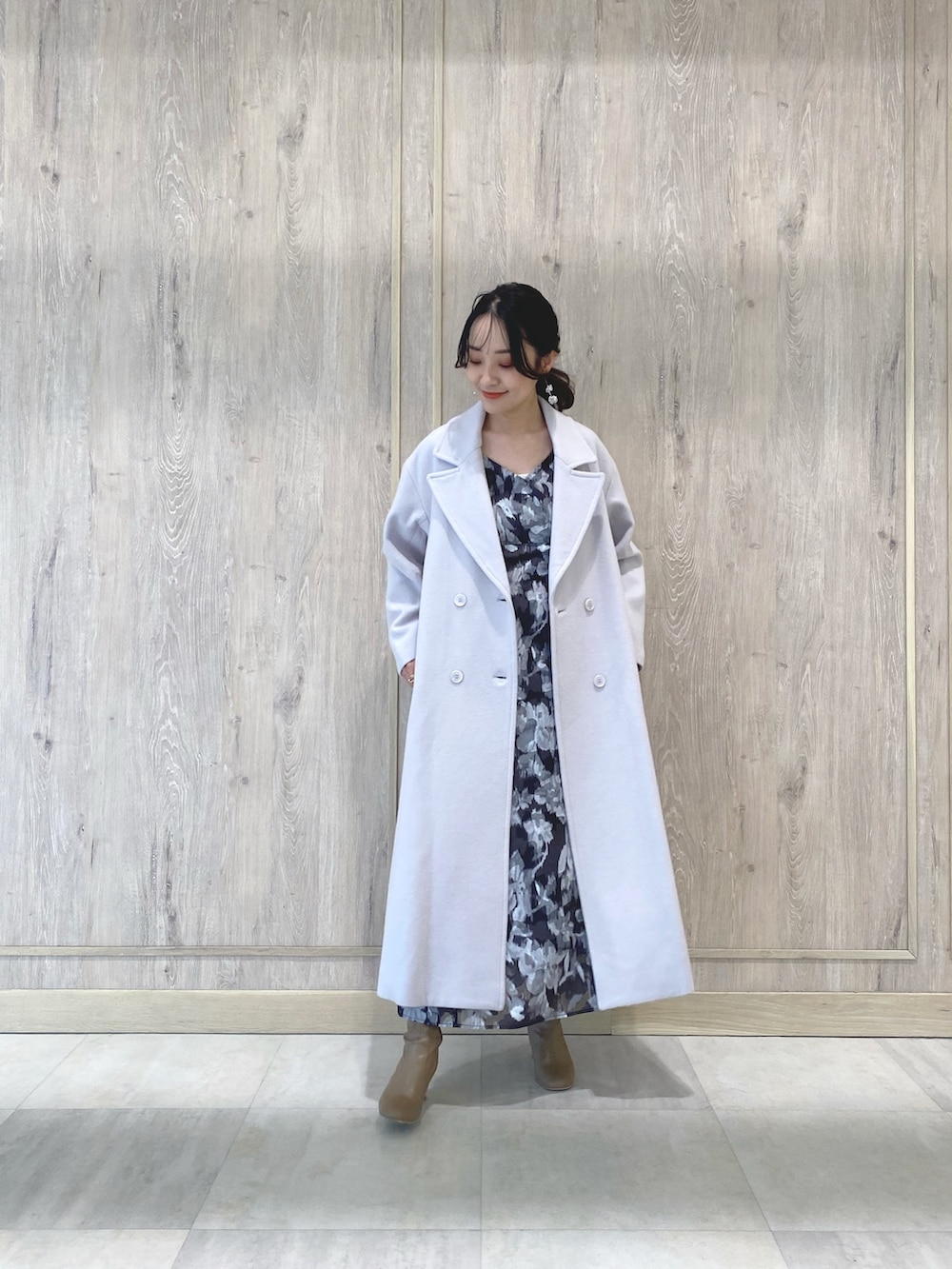 ベージュ系のブーツ、ピンク系のチェスターコート、ブラック系のワンピースを着用したレディースの冬コーディネートの2枚目の写真