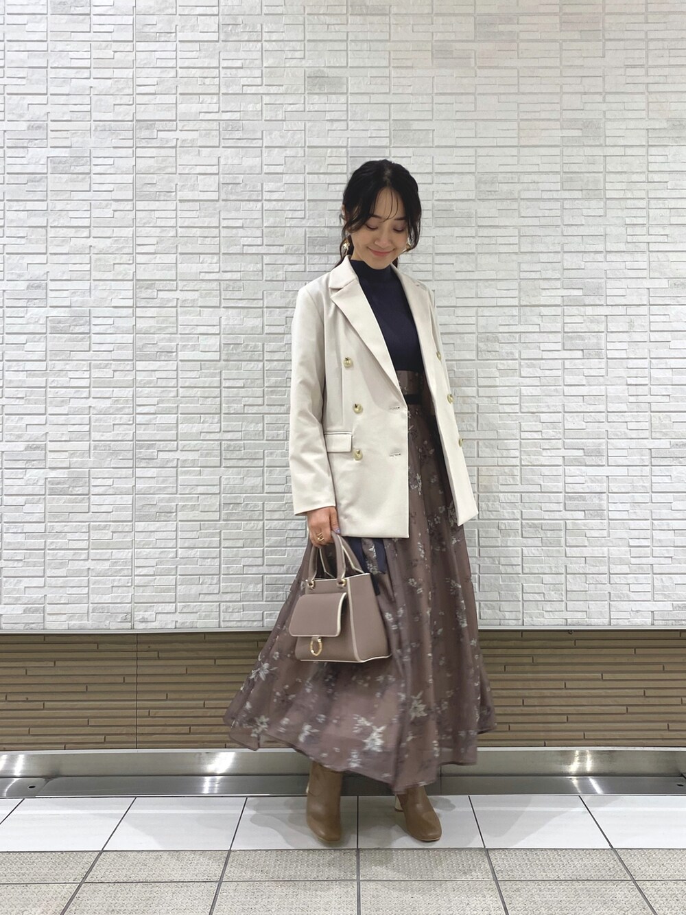 ベージュ系のブーツ、ホワイト系のテーラードジャケット、ベージュ系のハンドバッグを着用したレディースの冬コーディネートの2枚目の写真
