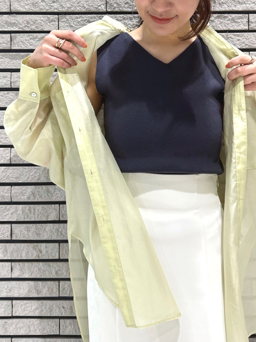 シルバー系のサンダル、ホワイト系のスカート、グレー系のニット/セーターを着用したレディースの春コーディネートの5枚目の写真