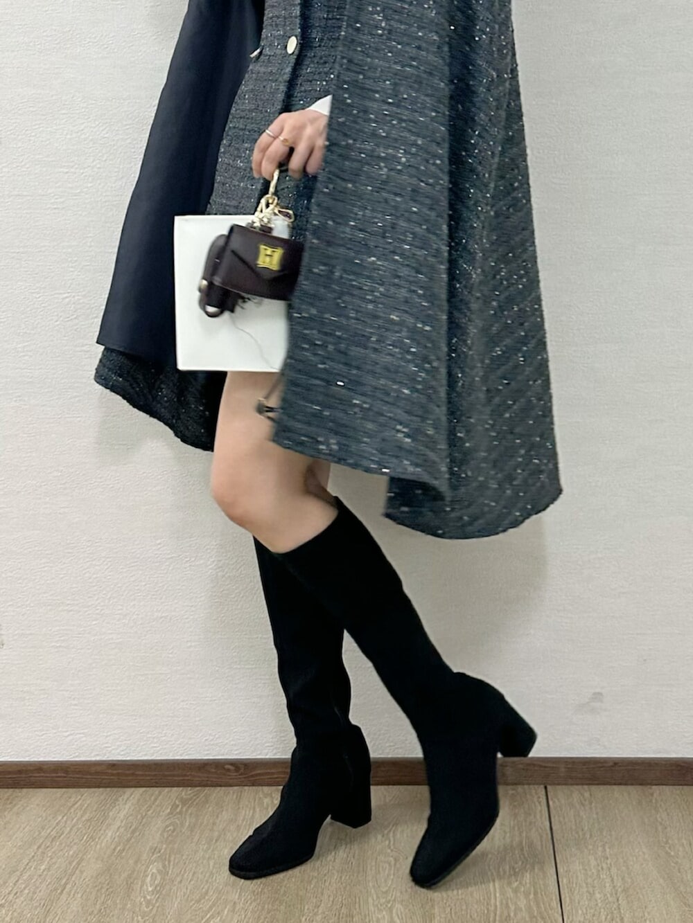 ブラウン系のショルダーバッグ、グレー系のワンピース、ブラック系のブーツを着用したレディースの秋コーディネートの5枚目の写真