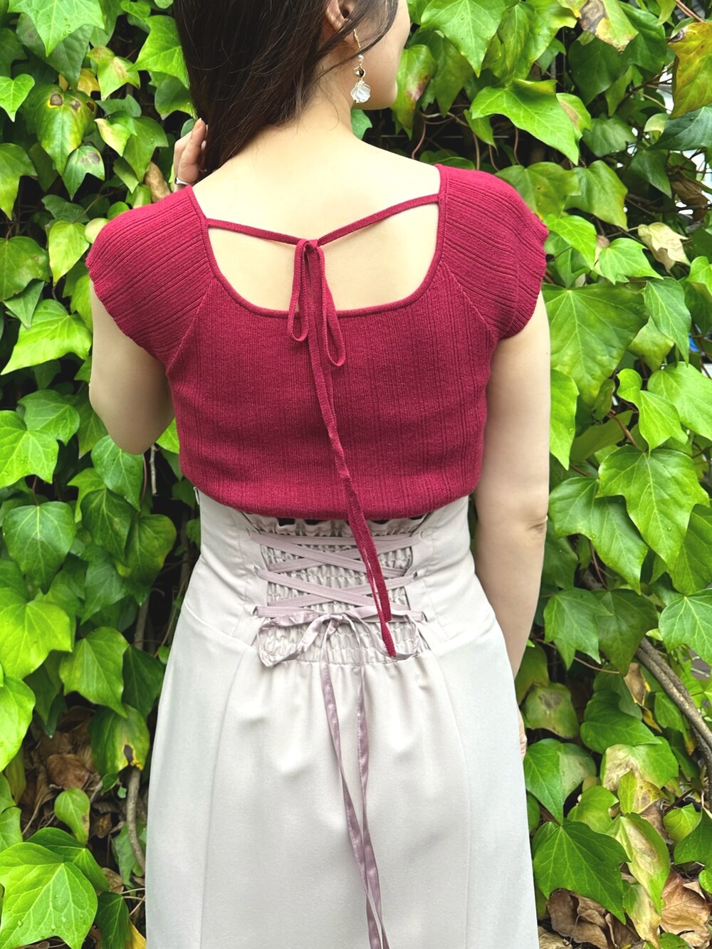 ブラウン系のサンダル、レッド系のニット/セーター、ピンク系のスカートを着用したレディースの夏コーディネートの5枚目の写真