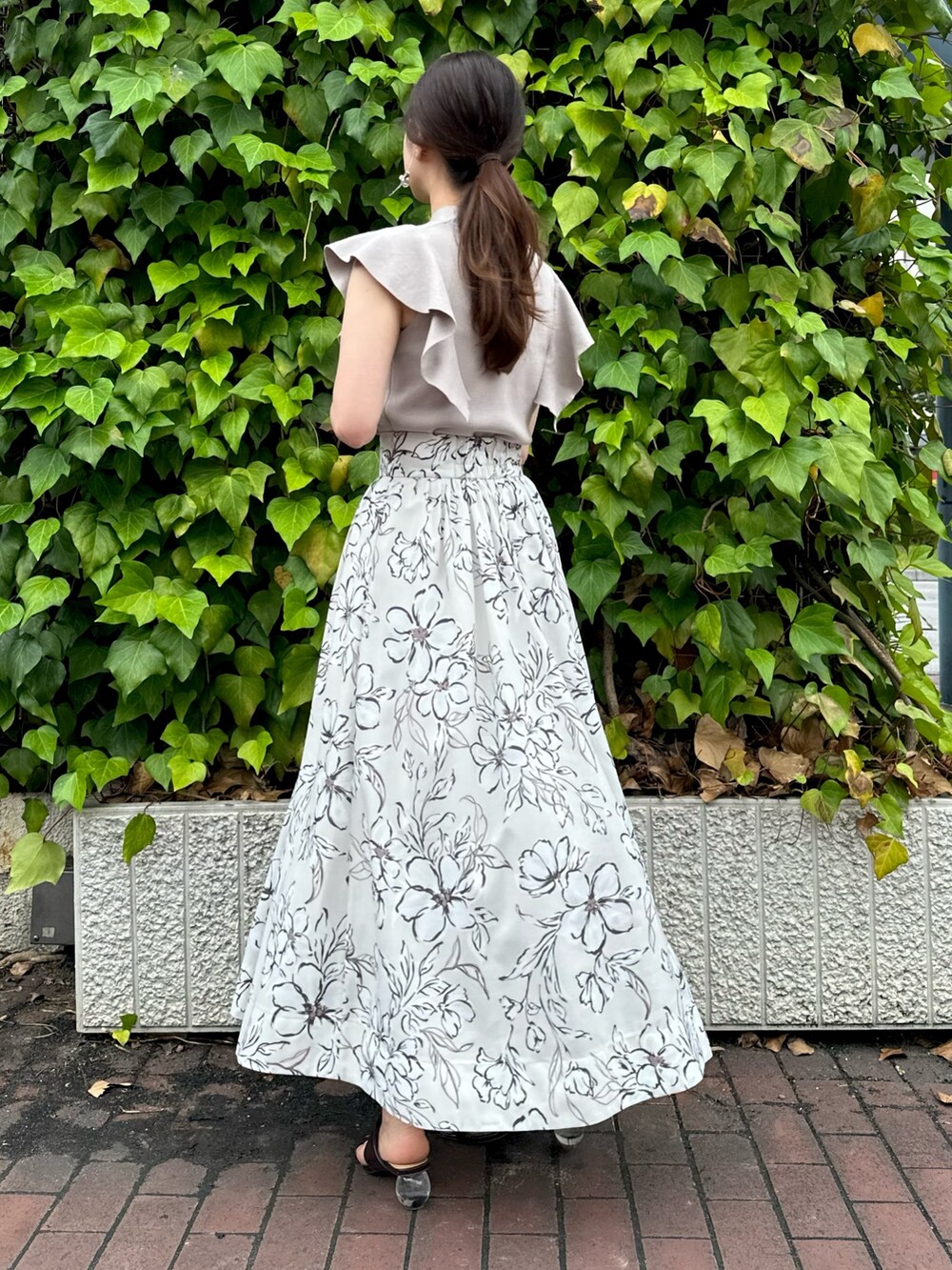 ブラウン系のサンダル、ホワイト系のスカート、ピンク系のニット/セーターを着用したレディースの夏コーディネートの3枚目の写真