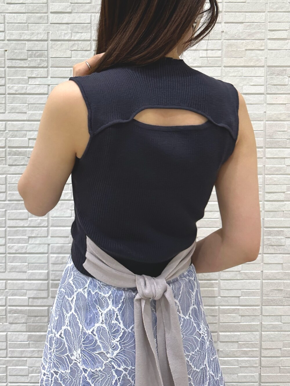 ブラック系のチューブトップ、ブルー系のスカート、ブラウン系のサンダルを着用したレディースの夏コーディネートの7枚目の写真