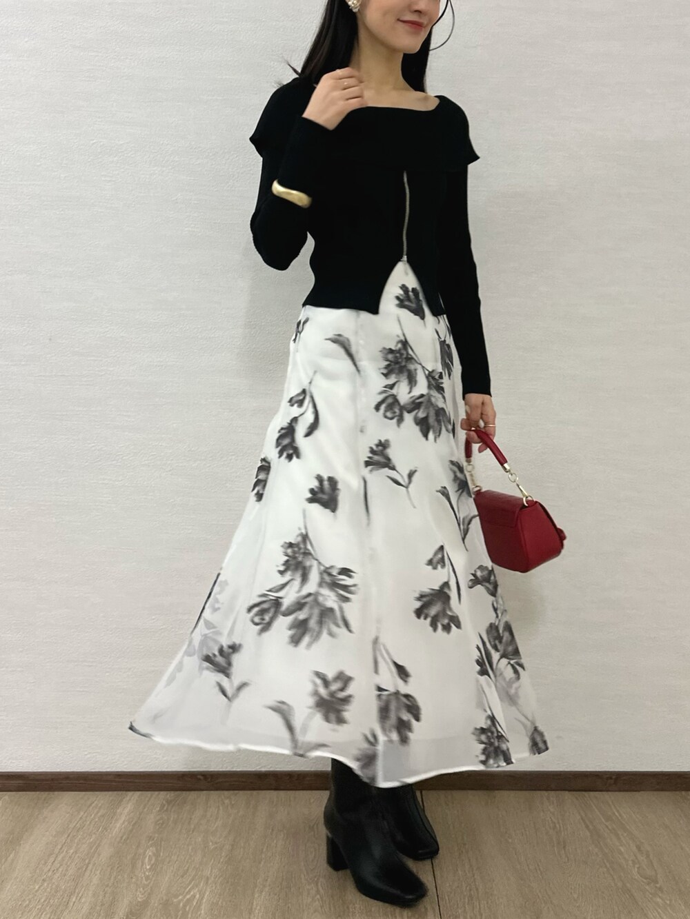 ブラック系のニット/セーター、ブラック系のブーツ、レッド系のハンドバッグを着用したレディースの秋コーディネートの2枚目の写真