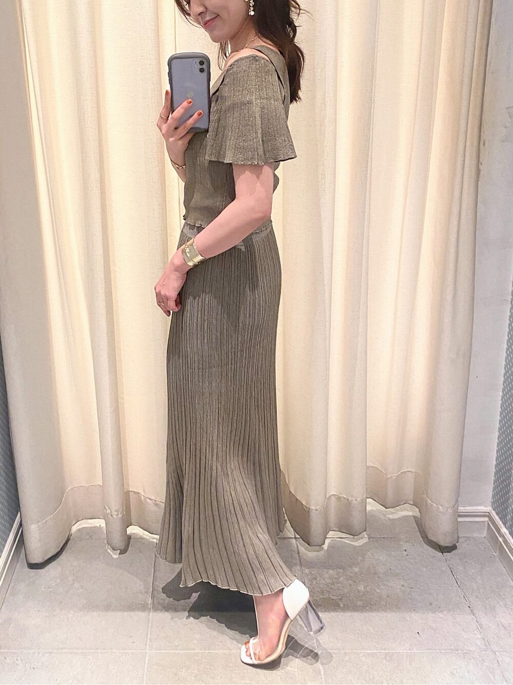 ベージュ系のワンピース、ホワイト系のその他シューズ、ゴールド系のネックレスを着用したレディースの夏コーディネートの3枚目の写真