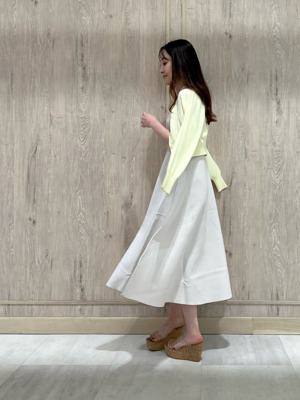 イエロー系のカーディガン/ボレロ、ホワイト系のワンピース、その他のサンダルを着用したレディースの春コーディネートの3枚目の写真