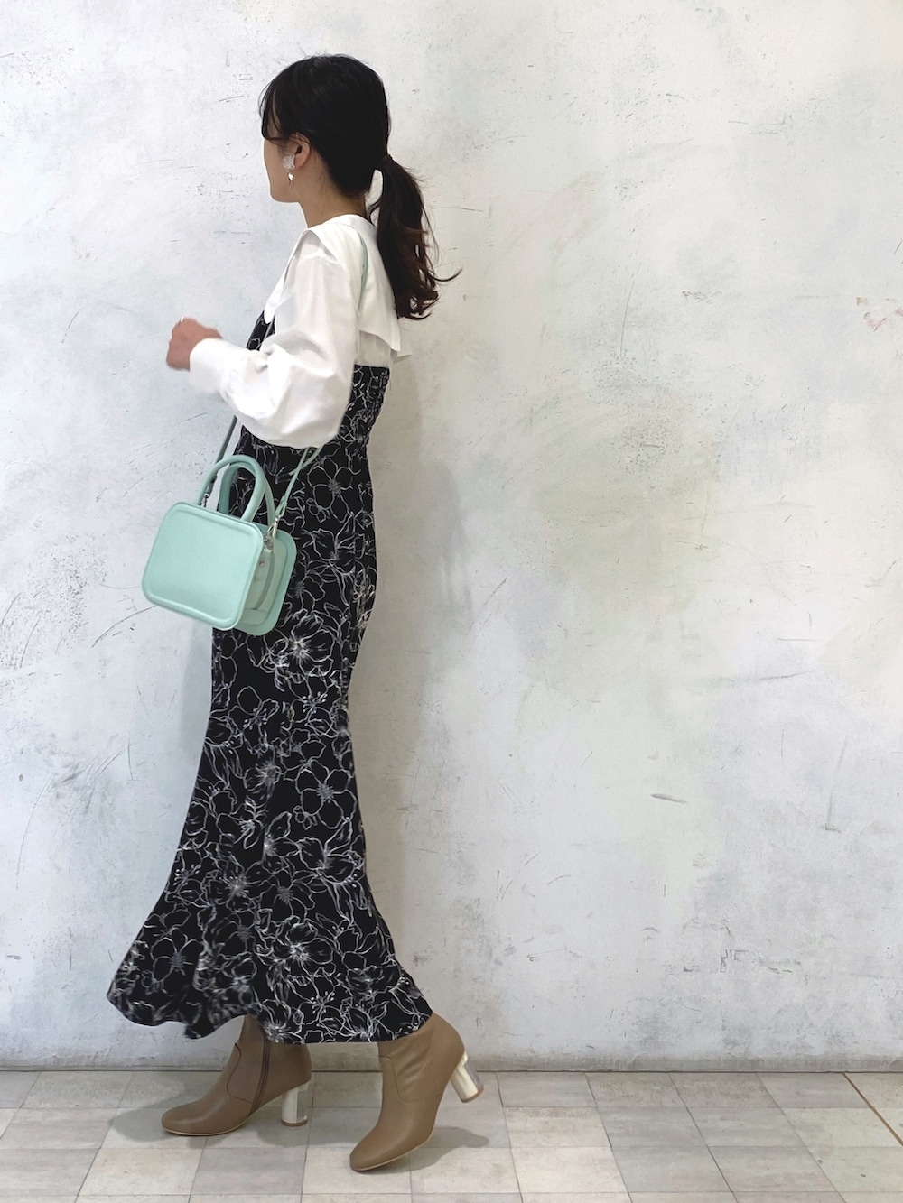 ベージュ系のブーツ、グリーン系のハンドバッグ、その他のワンピースを着用したレディースの冬コーディネートの3枚目の写真