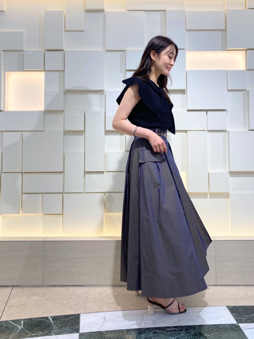 ブラック系のニット/セーター、ベージュ系のトートバッグ、ブラウン系のスカートを着用したレディースの夏コーディネートの7枚目の写真