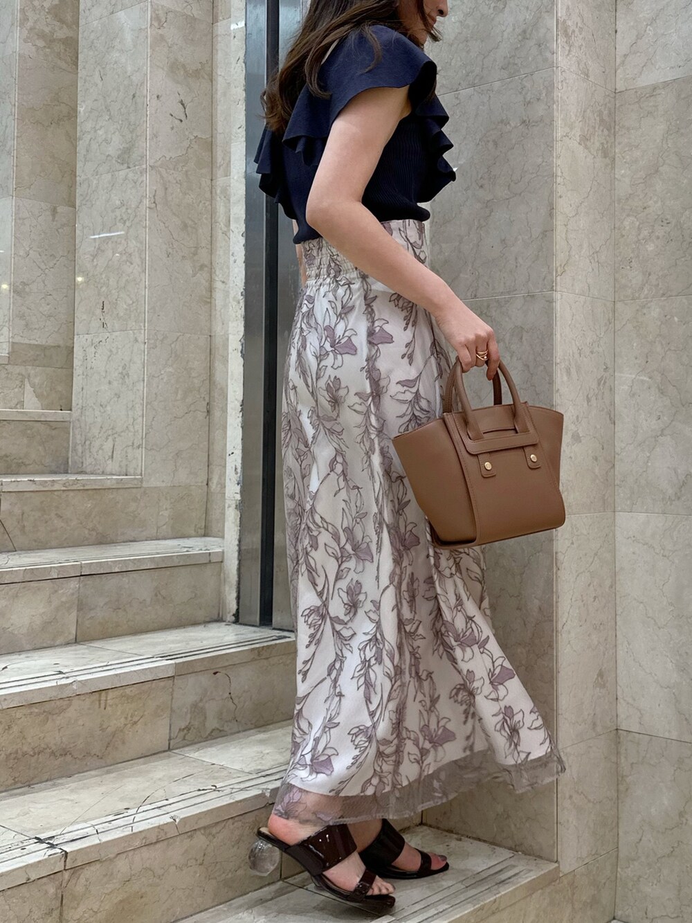 ブラック系のチューブトップ、ブラウン系のサンダル、ピンク系のスカートを着用したレディースの春コーディネートの2枚目の写真