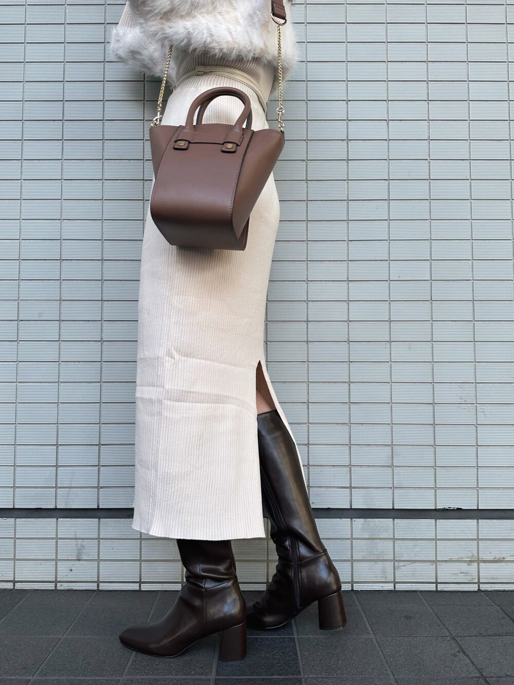 ブラウン系のハンドバッグ、ブラウン系のブーツ、ベージュ系のワンピースを着用したレディースの秋コーディネートの9枚目の写真