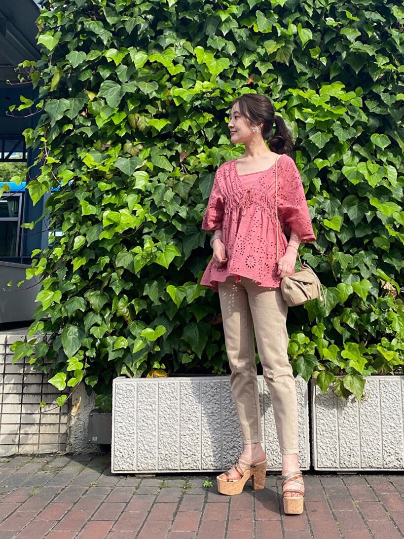 ベージュ系のその他パンツ、グリーン系のサンダル、ベージュ系のクラッチバッグを着用したレディースの春コーディネートの3枚目の写真