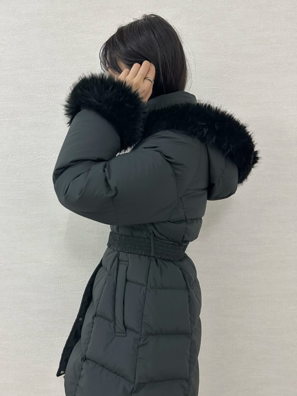 グリーン系のワンピース、ブラウン系のブーツ、ブラック系のダウンジャケット/コートを着用したレディースの冬コーディネートの9枚目の写真