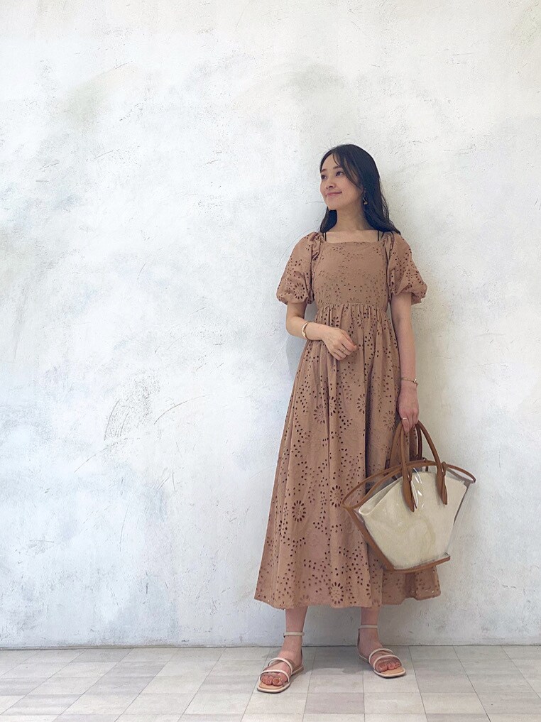 ブラウン系のトートバッグ、ベージュ系のワンピース、ベージュ系のサンダルを着用したレディースの春コーディネートの3枚目の写真