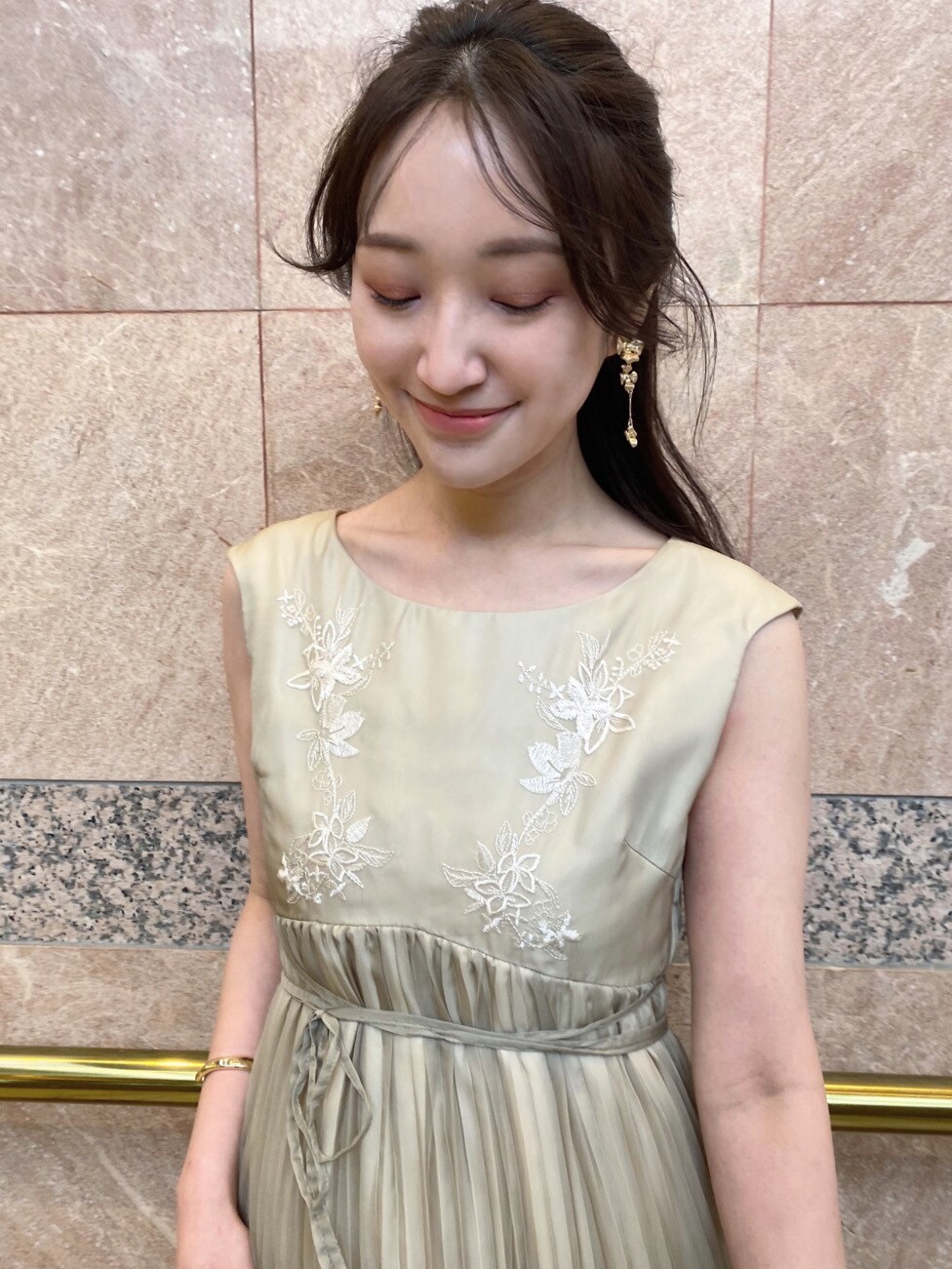 グリーン系のワンピース、ベージュ系のパンプス、ベージュ系のクラッチバッグを着用したレディースの春コーディネートの4枚目の写真