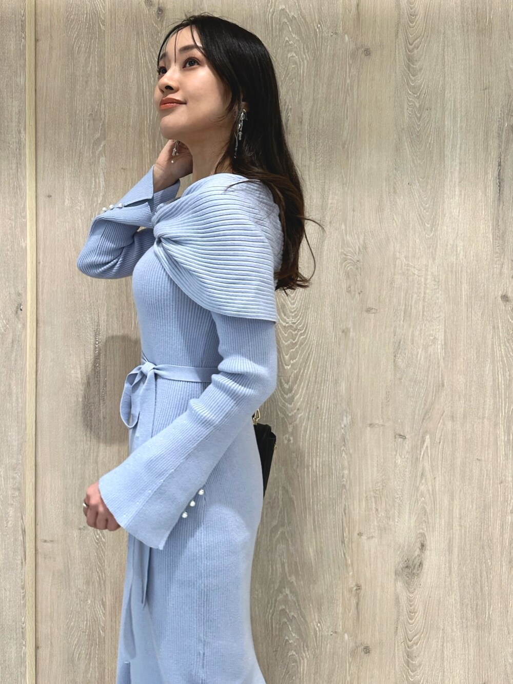 ブラック系のブーツ、ブルー系のワンピース、ブラック系のショルダーバッグを着用したレディースの冬コーディネートの6枚目の写真