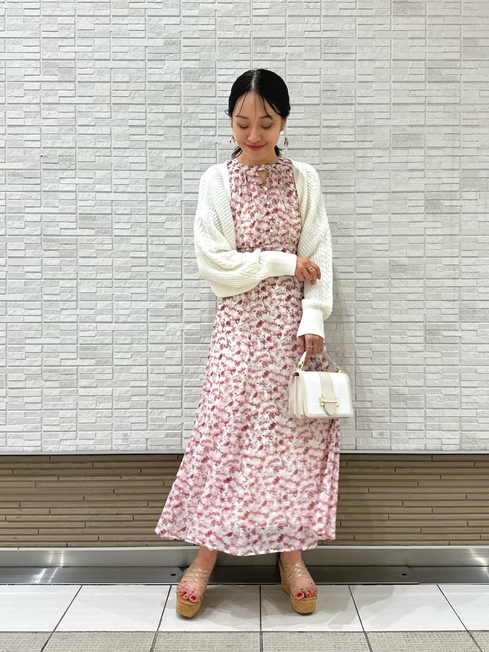 ホワイト系のカーディガン/ボレロ、ホワイト系のハンドバッグ、ピンク系のワンピースを着用したレディースの春コーディネートの2枚目の写真