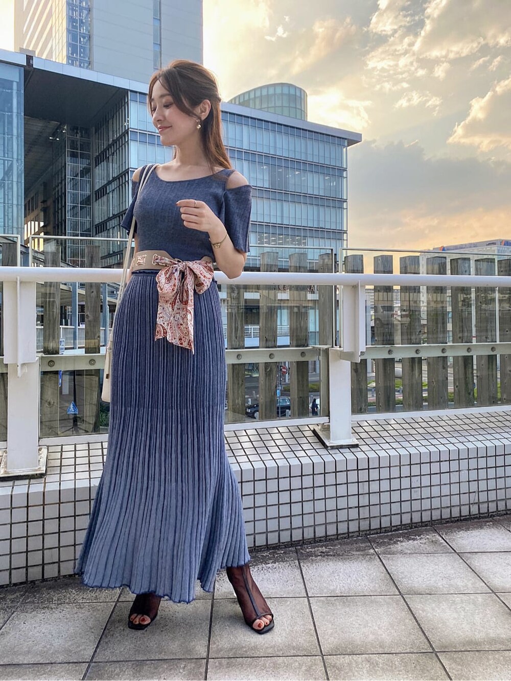 ブルー系のワンピース、ブラウン系のその他シューズ、ホワイト系のハンドバッグを着用したレディースの夏コーディネートの2枚目の写真