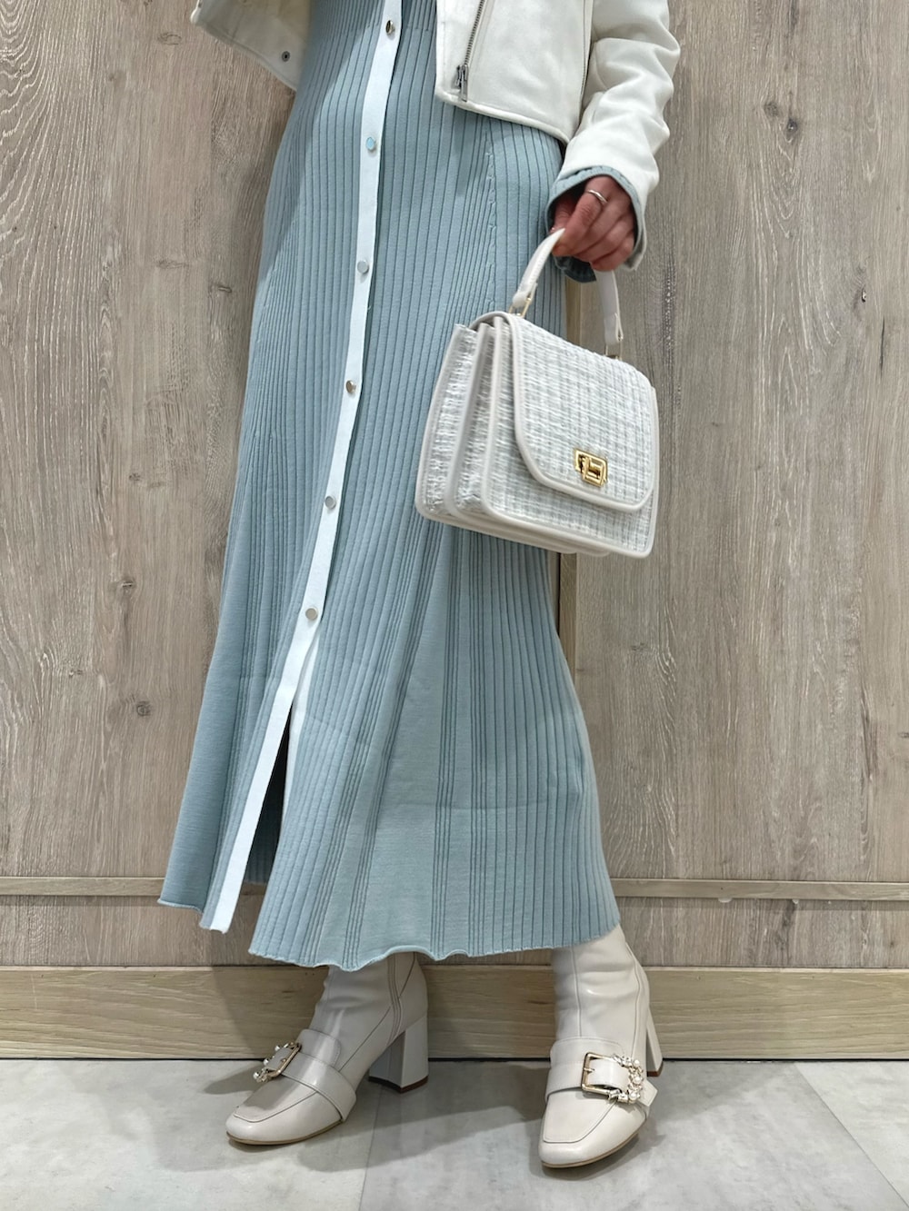 ホワイト系のハンドバッグ、ホワイト系のブーツ、ブルー系のワンピースを着用したレディースの冬コーディネートの7枚目の写真