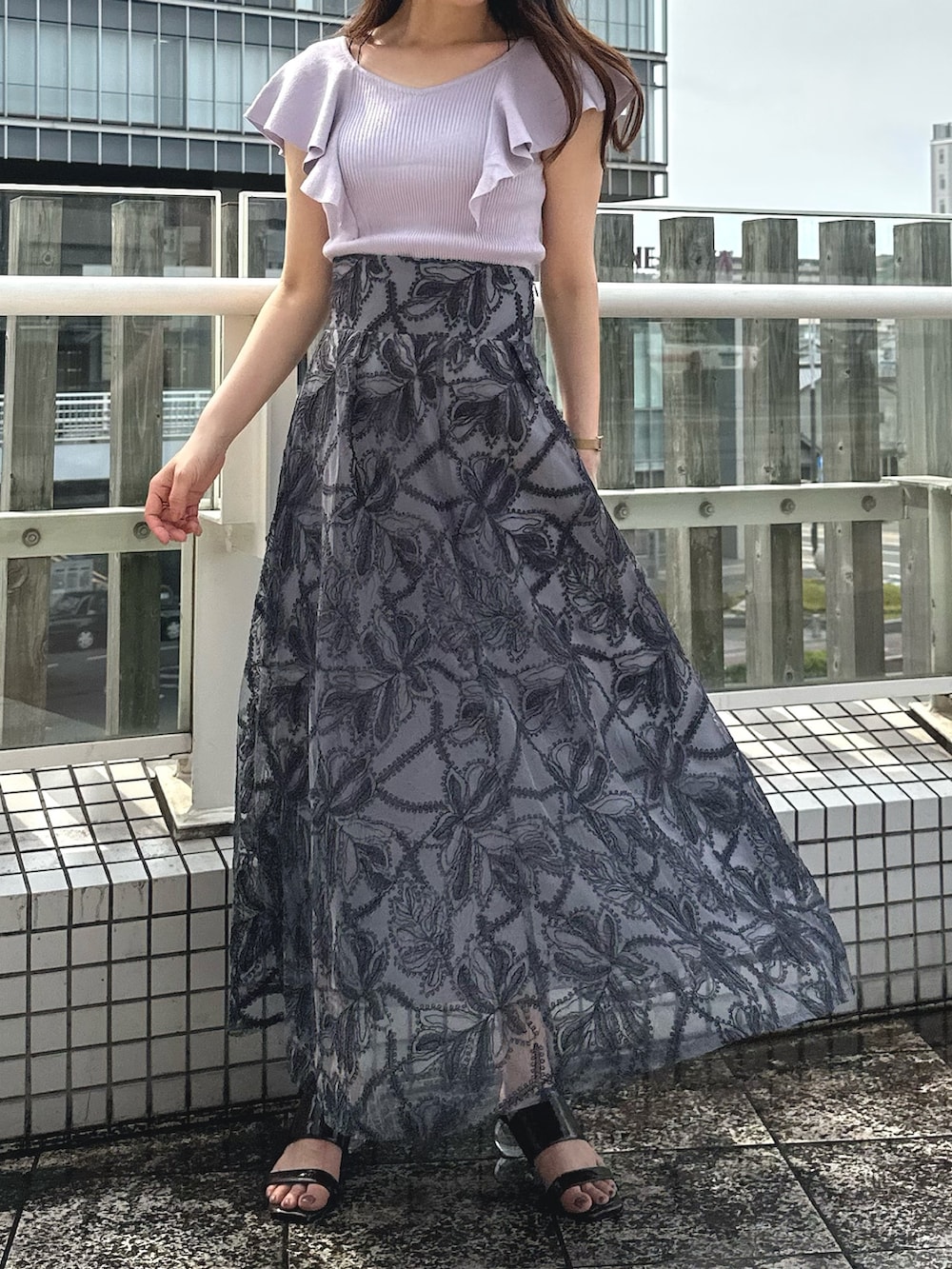 ブラウン系のサンダル、ブラック系のチューブトップ、グレー系のスカートを着用したレディースの夏コーディネートの2枚目の写真