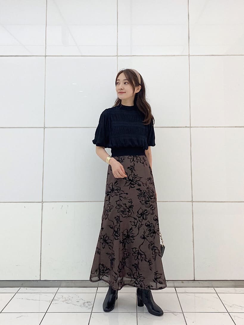 ブラウン系のスカート、ブラック系のニット/セーター、ブラック系のハンドバッグを着用したレディースの夏コーディネートの2枚目の写真