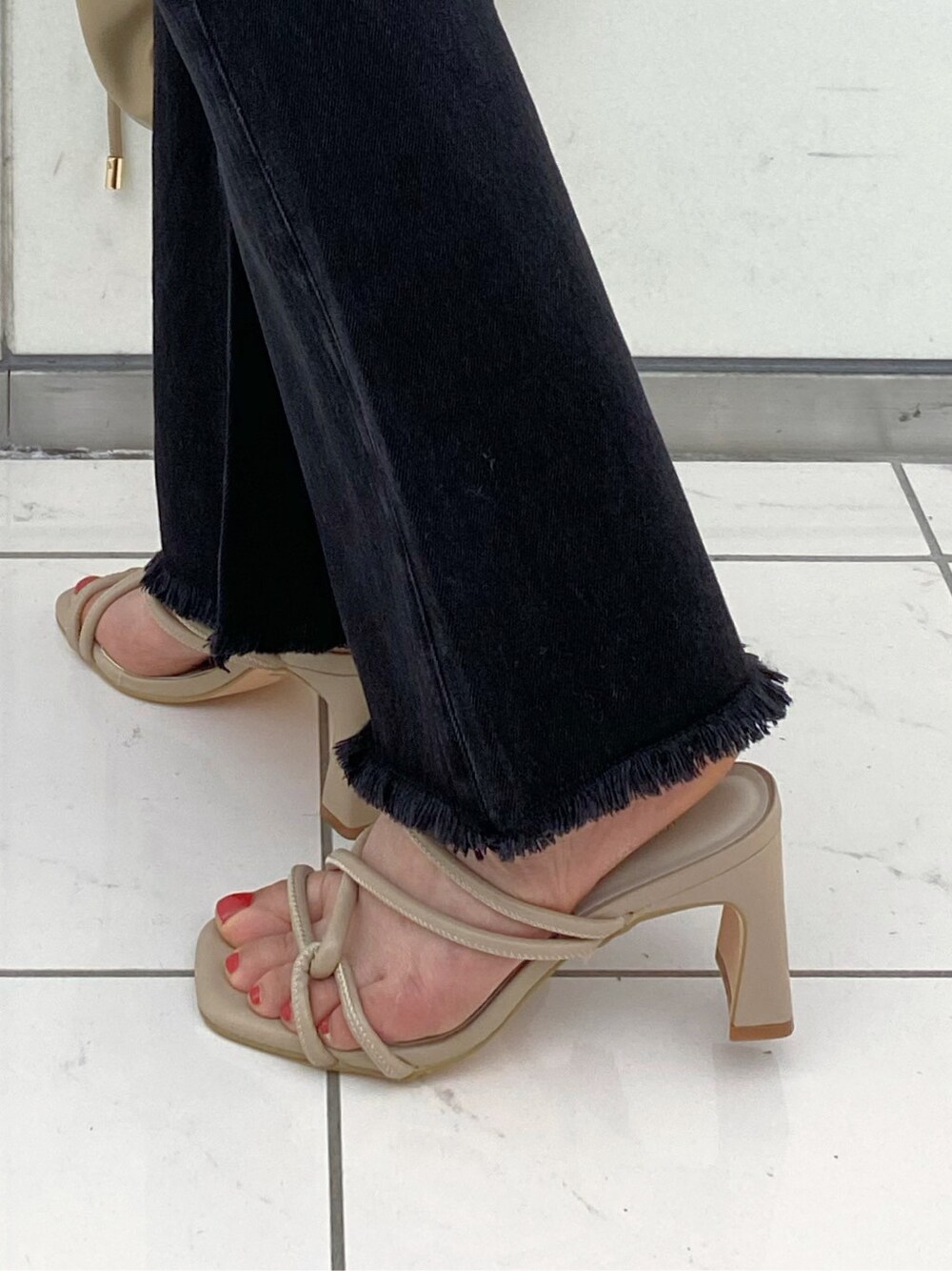 ブラック系のサロペット/オーバーオール、レッド系のシャツ/ブラウス、ベージュ系のサンダルを着用したレディースの春コーディネートの7枚目の写真